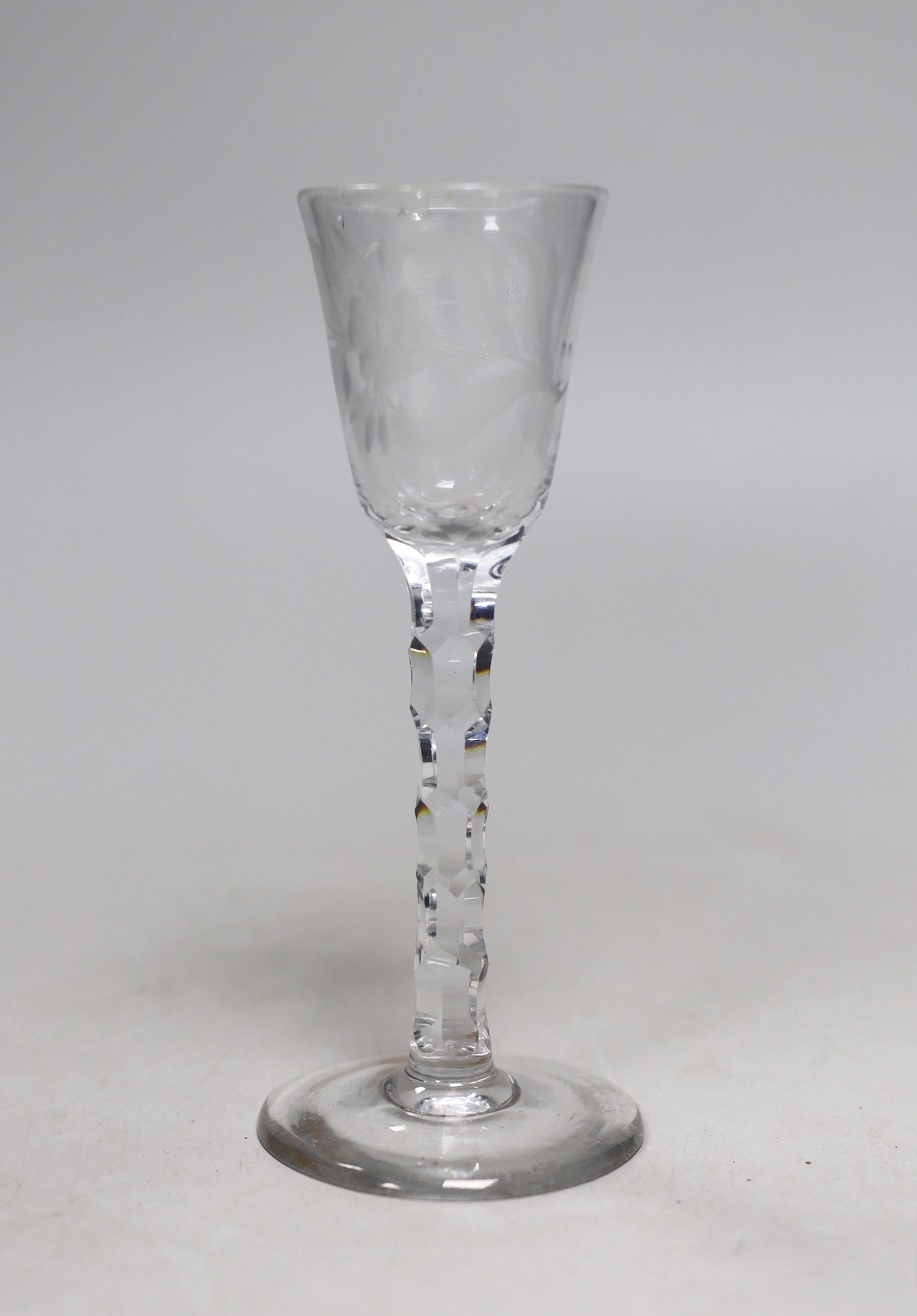 A George III facet stem wine or cordial glass, wheel engraved flowers. 16.5cm tall